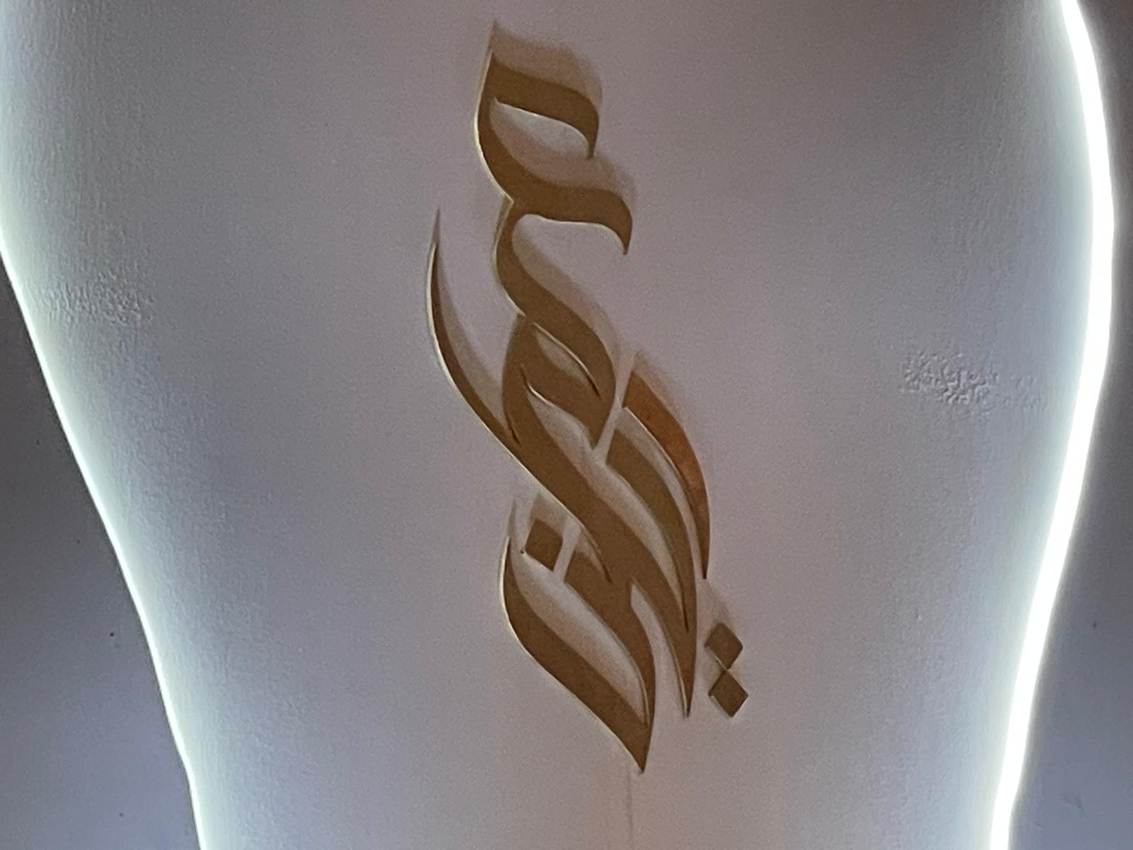 Gold Arabic calligraphy stage decoration at a fundraising event